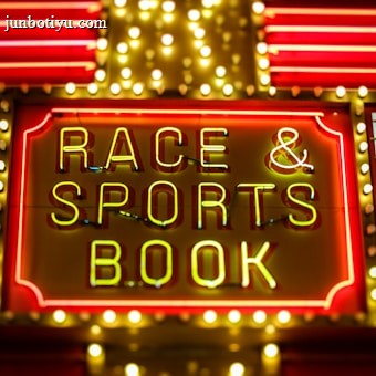 Bright neon lights on a marquee sign display the words 'RACE & SPORTS BOOK'. The sign is surrounded by rows of yellow and white lights against a red background, evoking a vibrant, energetic atmosphere typically associated with casinos or entertainment venues.